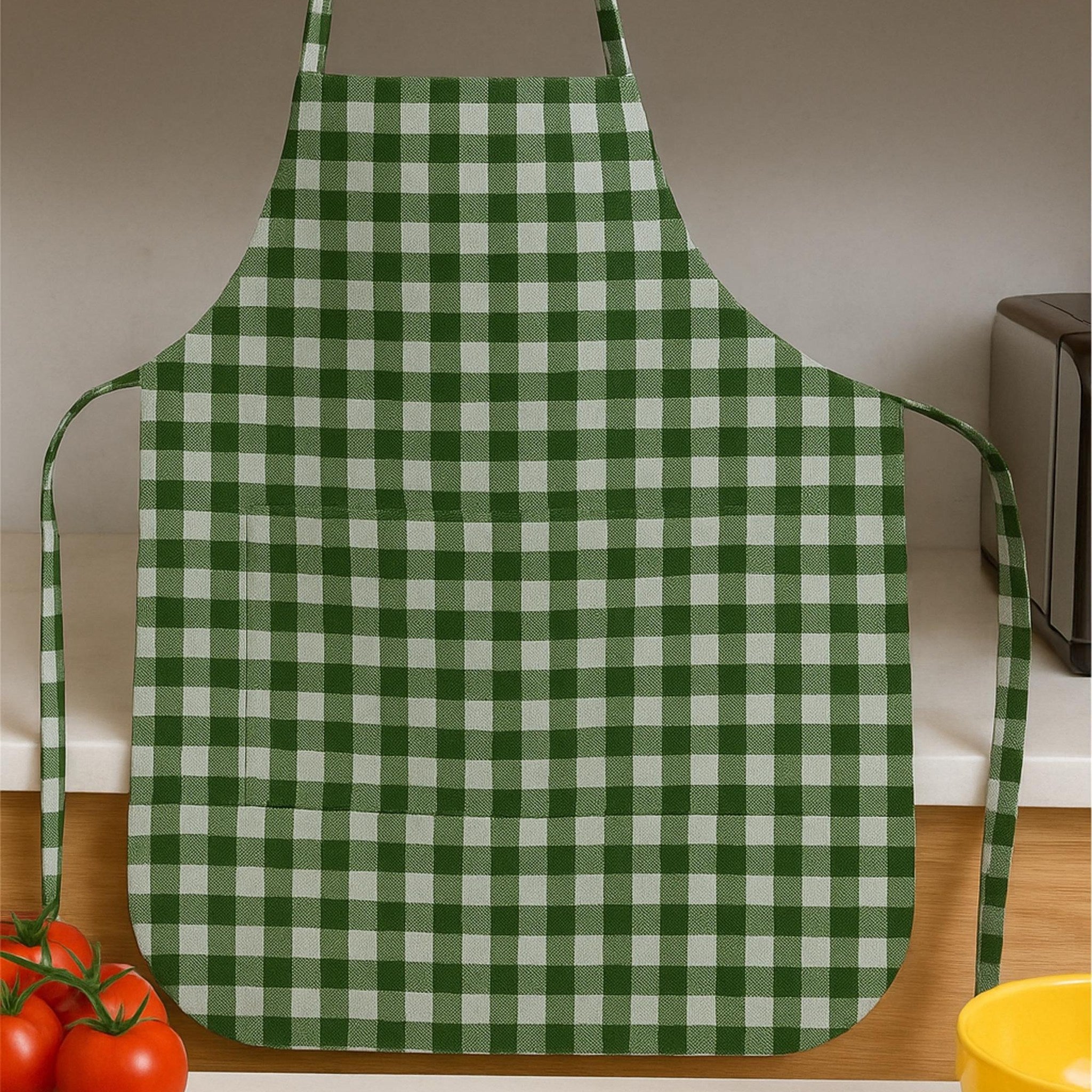 Gingham apron hanging in kitchen with cooking scene