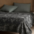 Gray and copper velvet bedspread on a bed