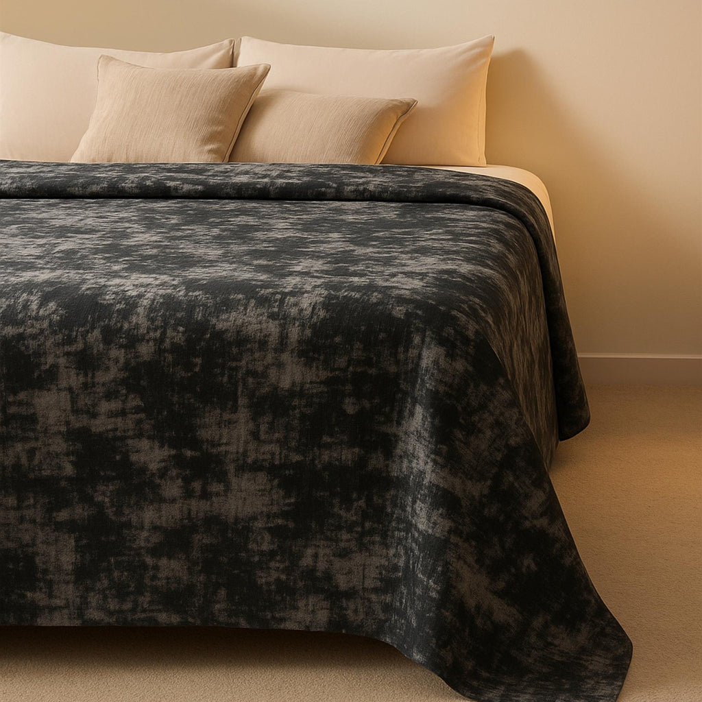 Gray bedspread in warm-lit bedroom