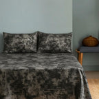 Velvet bedspread on bed with blue wall