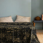 Black bedspread in light blue bedroom