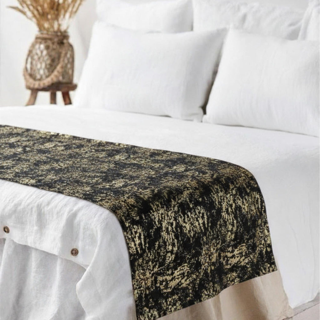Black gold runner at foot of white bed