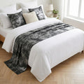Gray and silver velvet bed runner on a white bed