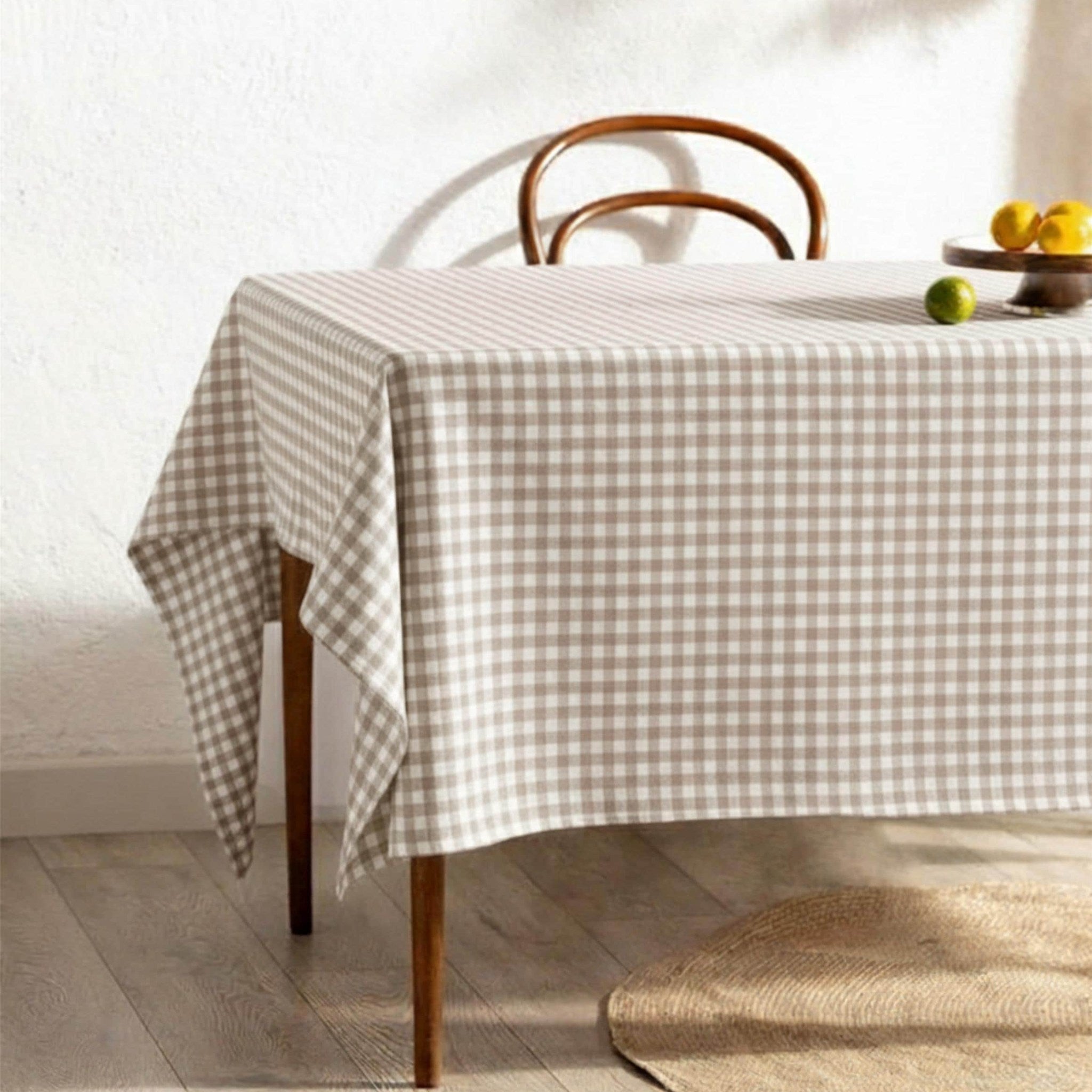 Beige gingham check cotton tablecloth on a farmhouse dining table