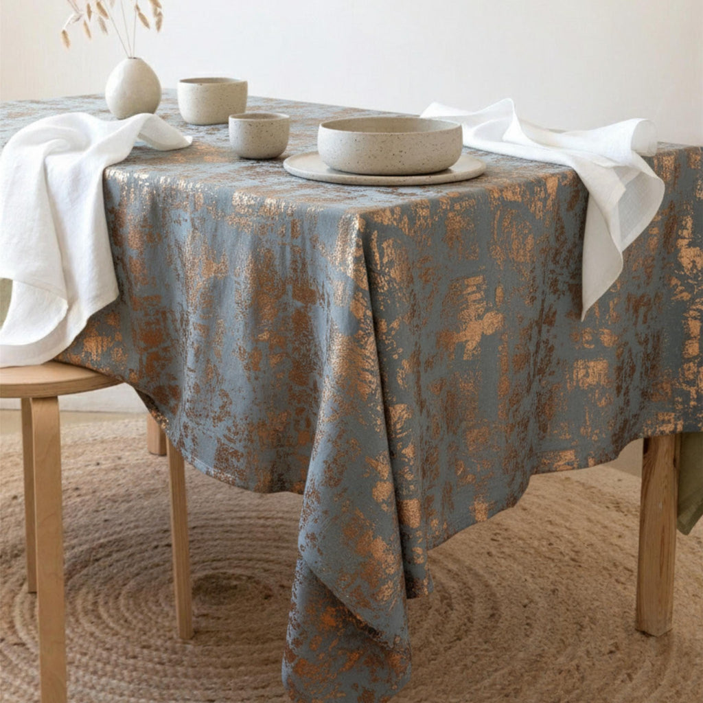 Gray and copper velvet tablecloth with distressed metallic pattern on a table