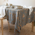 Gray and copper velvet tablecloth with distressed metallic pattern on a table