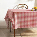 Red and white gingham cotton tablecloth on a rustic kitchen table
