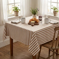 Dark beige striped cotton tablecloth on a rustic wooden dining table