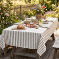 Gray striped cotton tablecloth draped over a modern dining table
