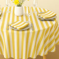 Yellow striped cotton tablecloth on a sunlit summer dining table