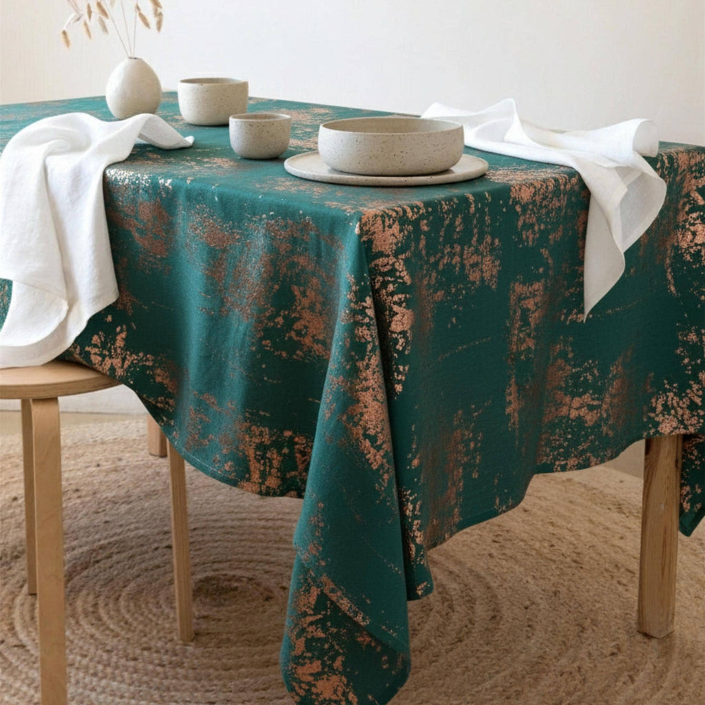 Emerald green velvet tablecloth with copper accents on a dining table