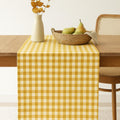 Yellow gingham cotton table runner on dining table