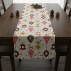 Beige Christmas table runner on dark wood table with pinecones