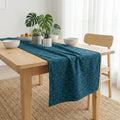 Navy blue geometric cube velvet table runner on light wood table