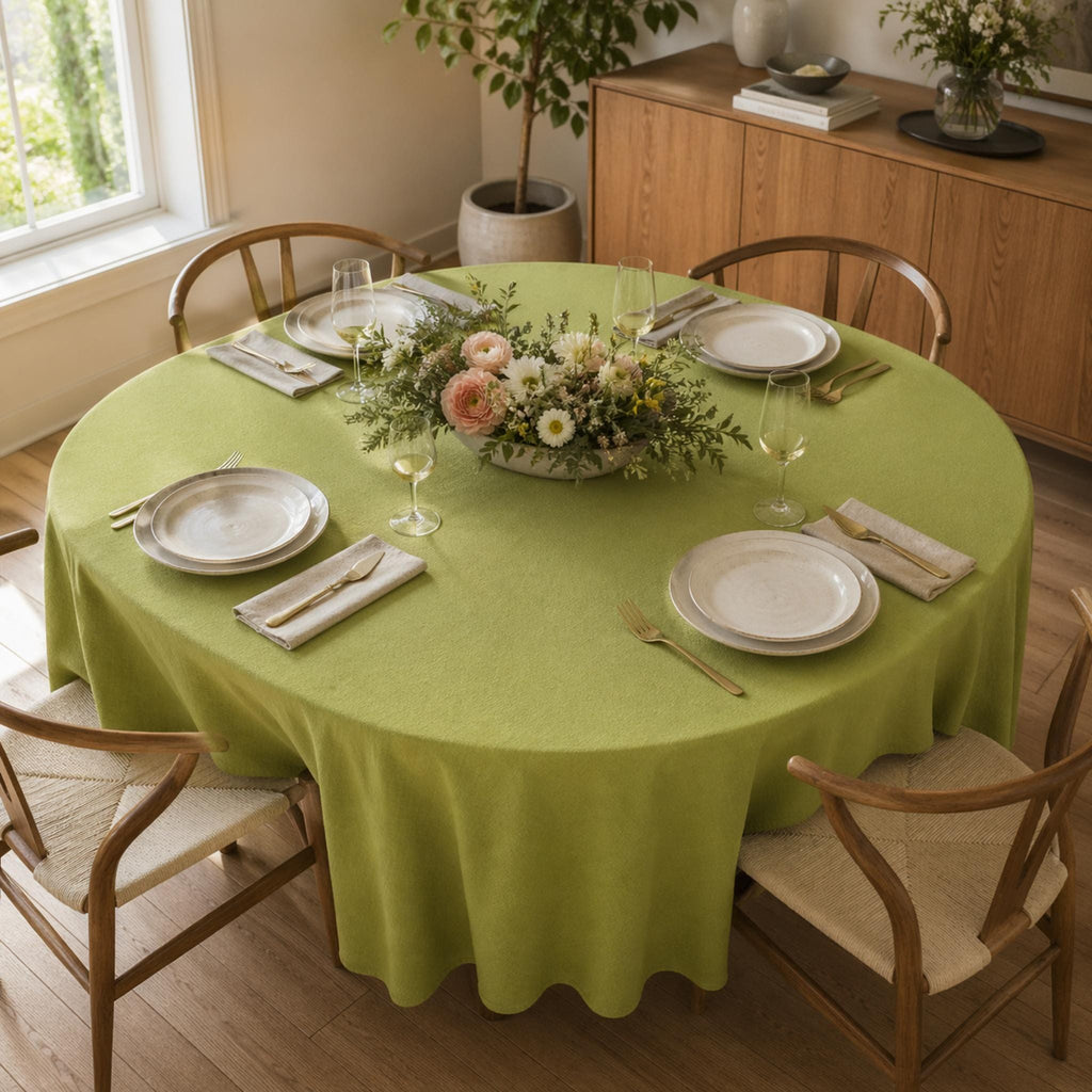 Round table with green tablecloth and gold cutlery