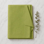 Folded green linen napkins detail